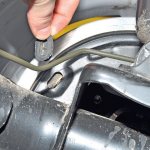 Removing the inspection window plug to check brake pad wear on Lada Kalina